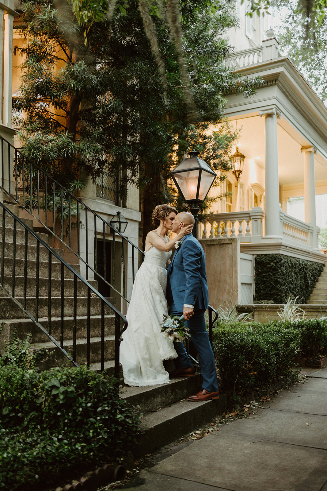 the bride and groom kiss on the street in Savannah Georgia