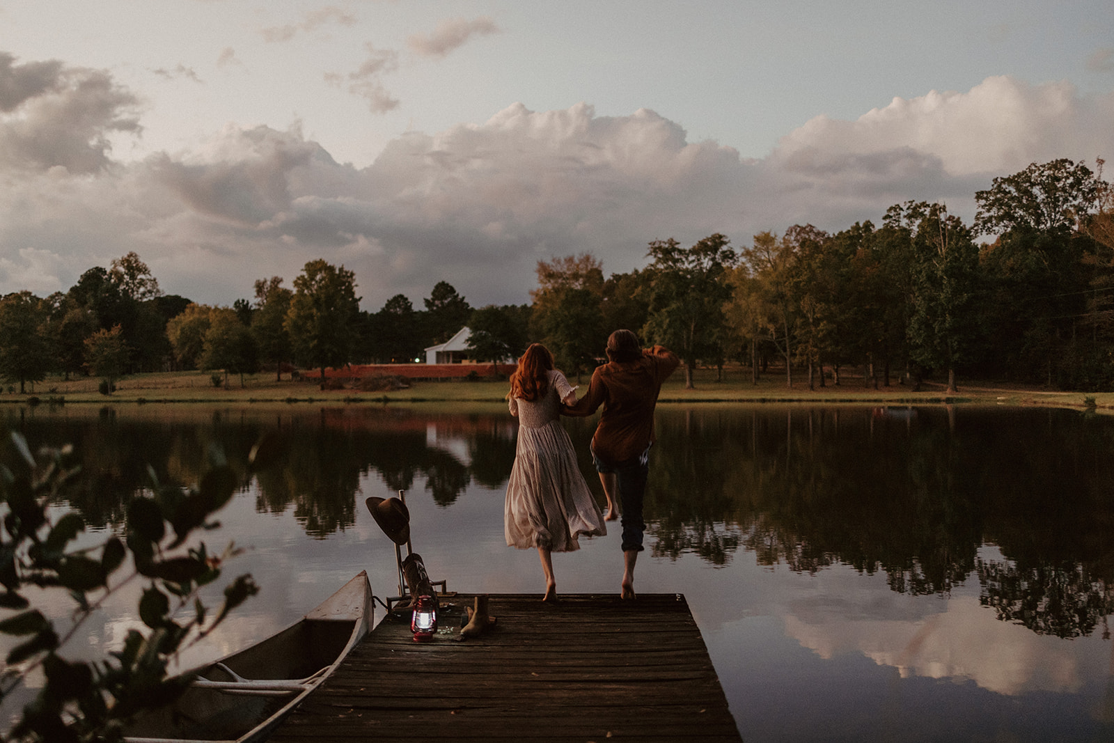 the couple jumps off the dock into the water