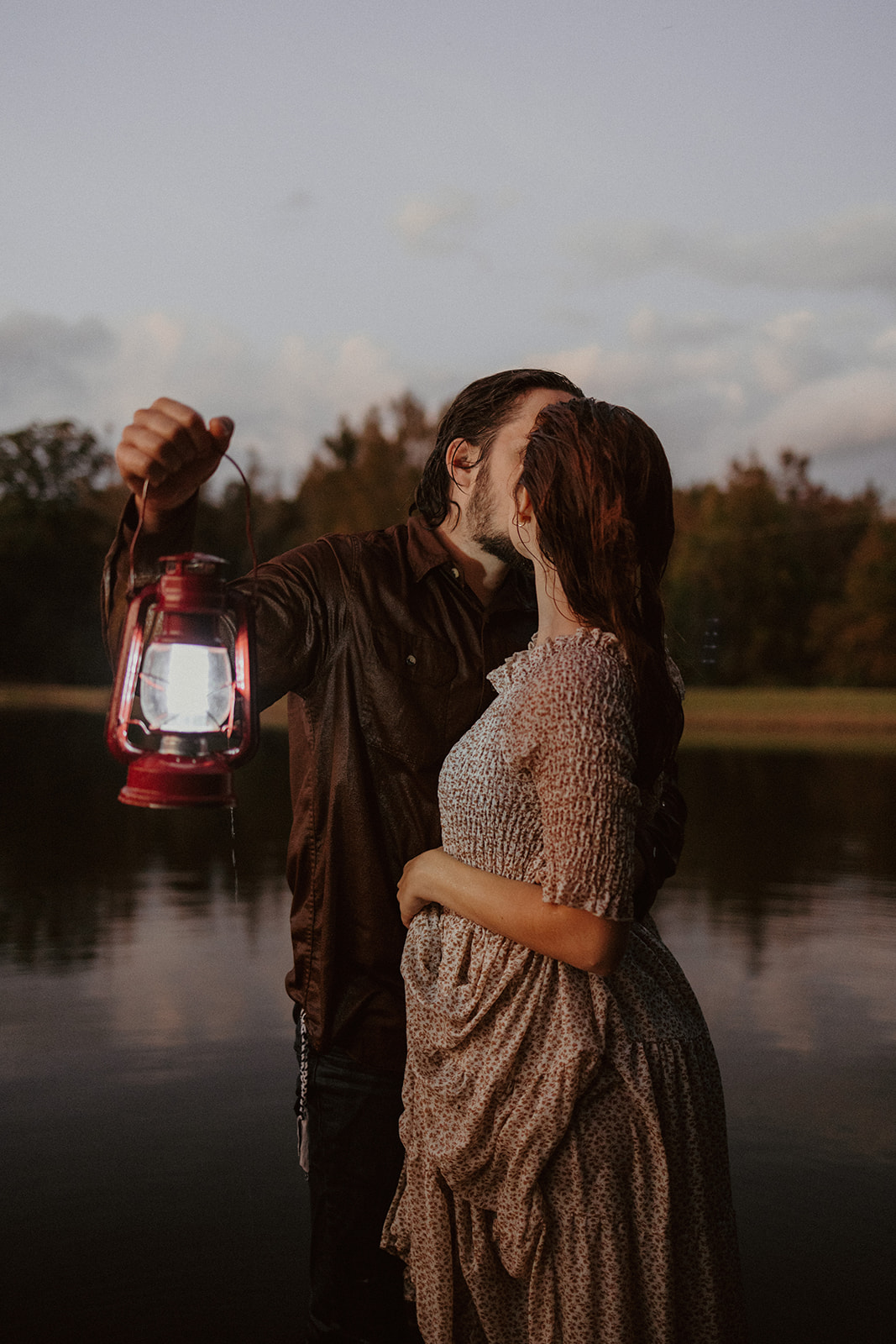 husband holds the lantern as he kisses his wife