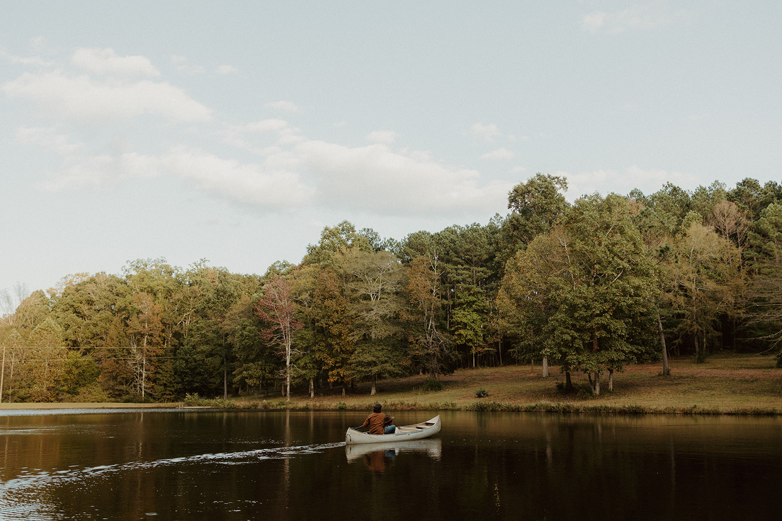 the couple paddles across the lake in their canoe in Georgia