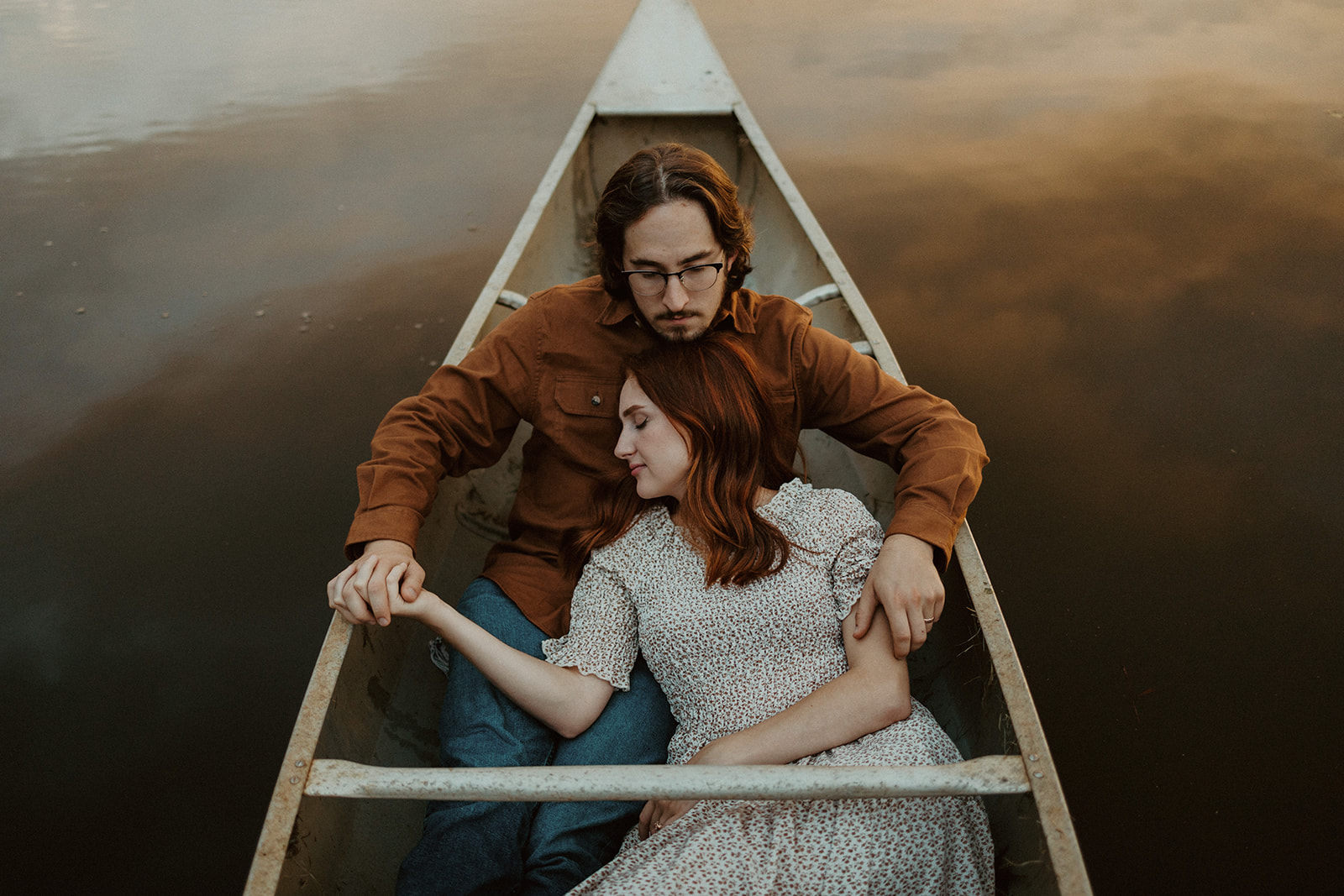 husband and wife cuddle in canoe as a couple photoshoot idea