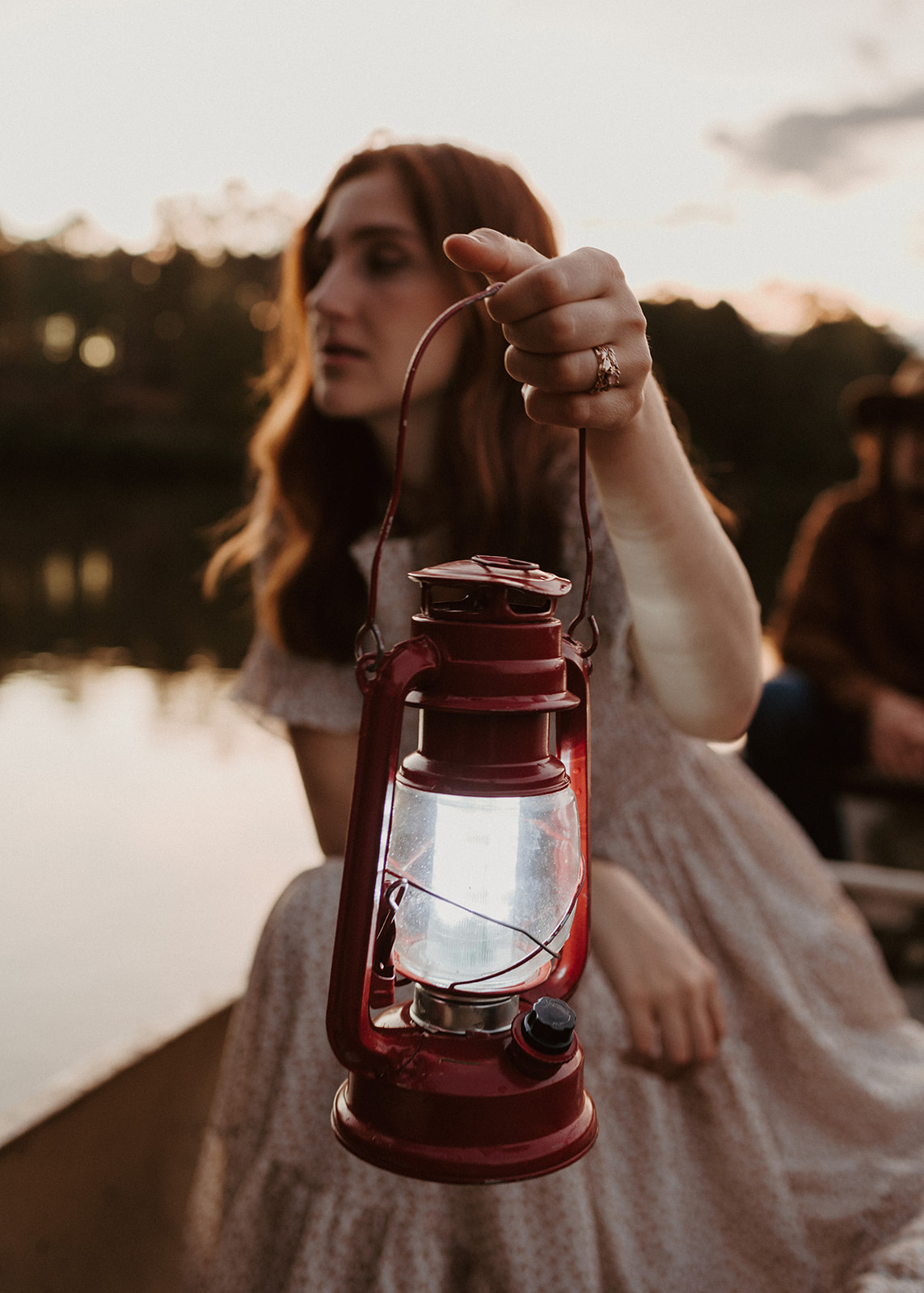 the wife holds a lantern as they canoe