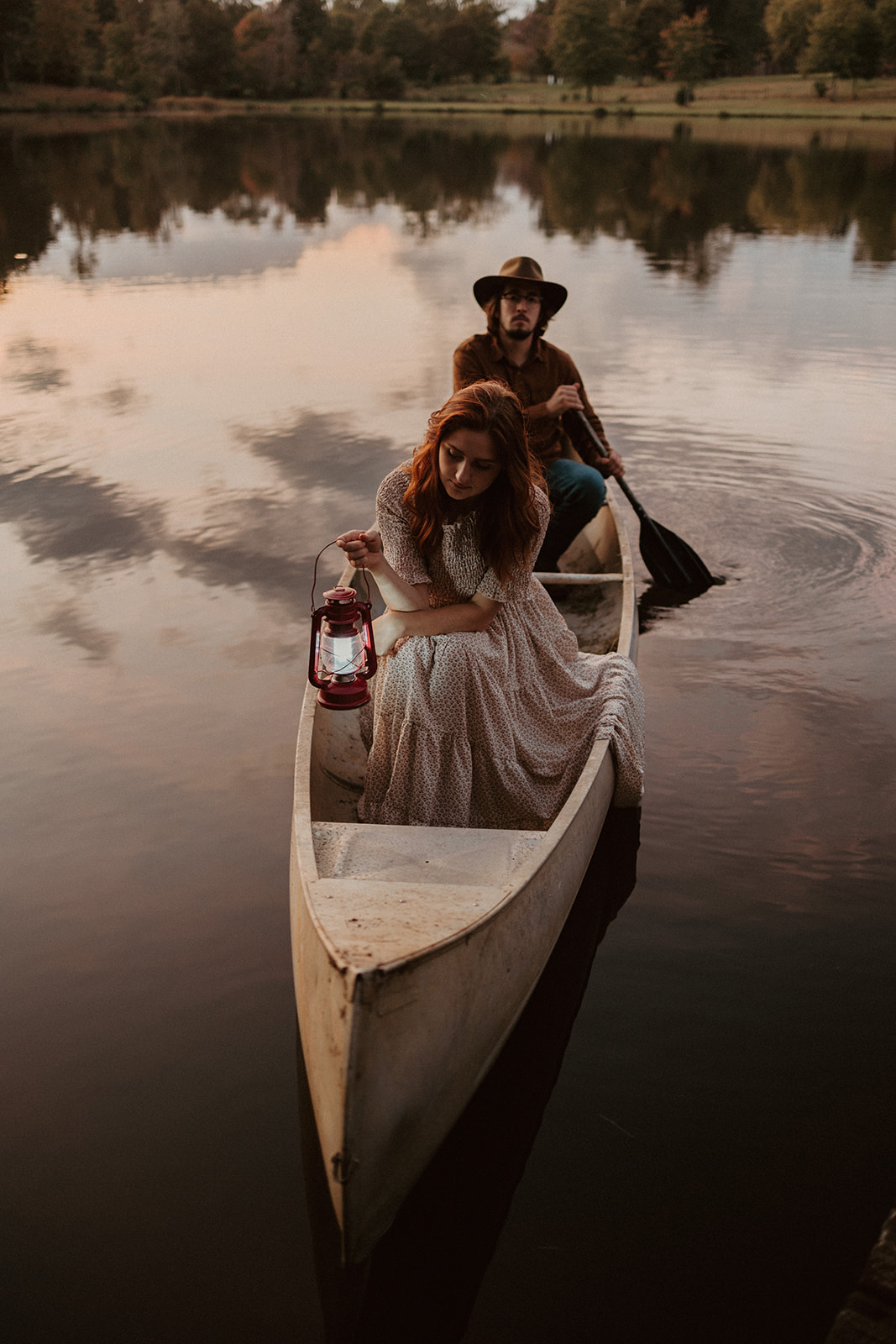 the couple rides together at sunset in their canoe