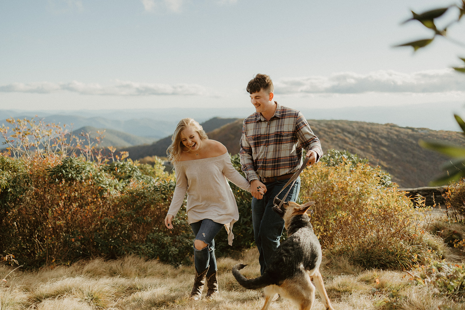 the couple walking with their dog on the mountain