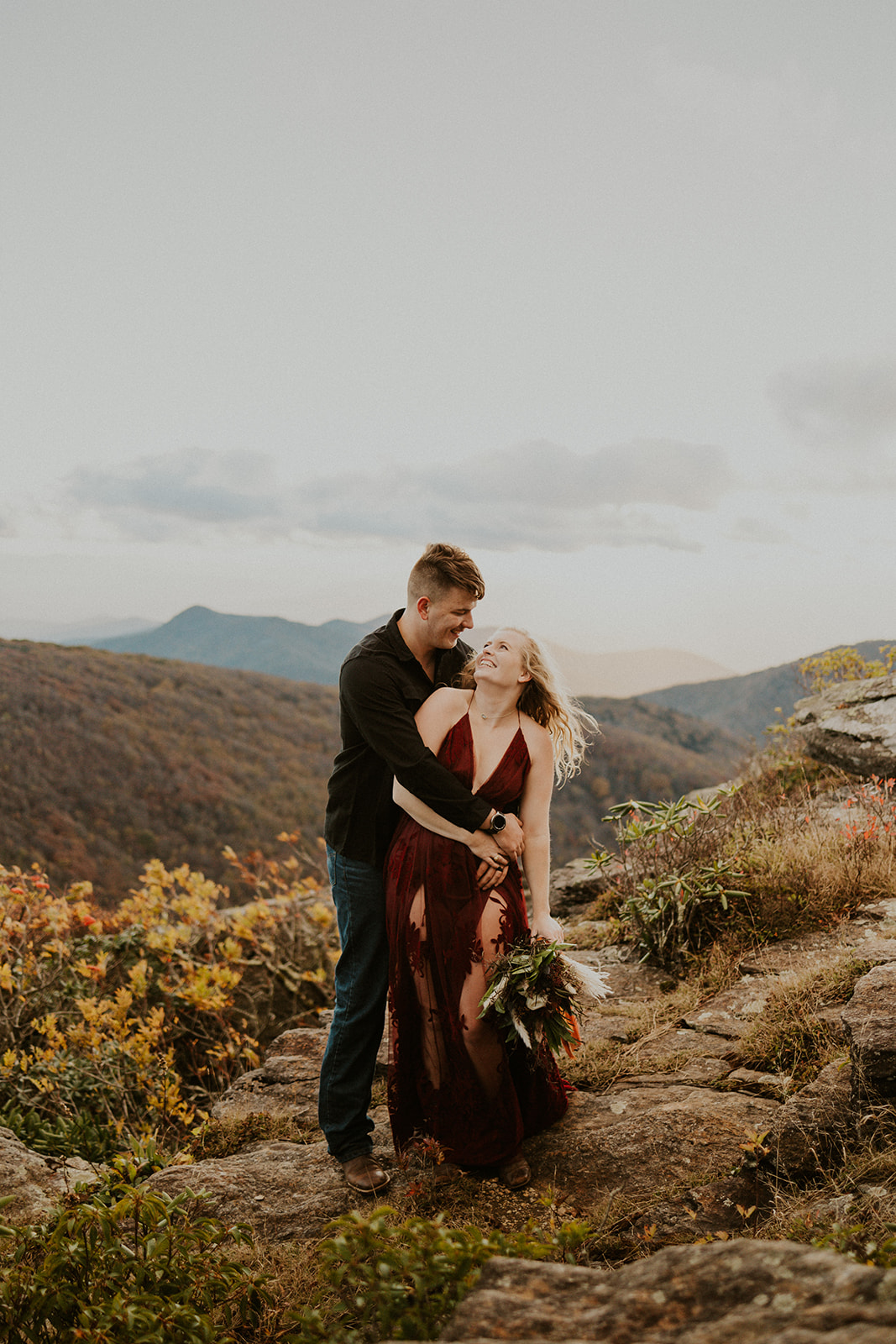 the couple smiling in Asheville during their engagement photos fall