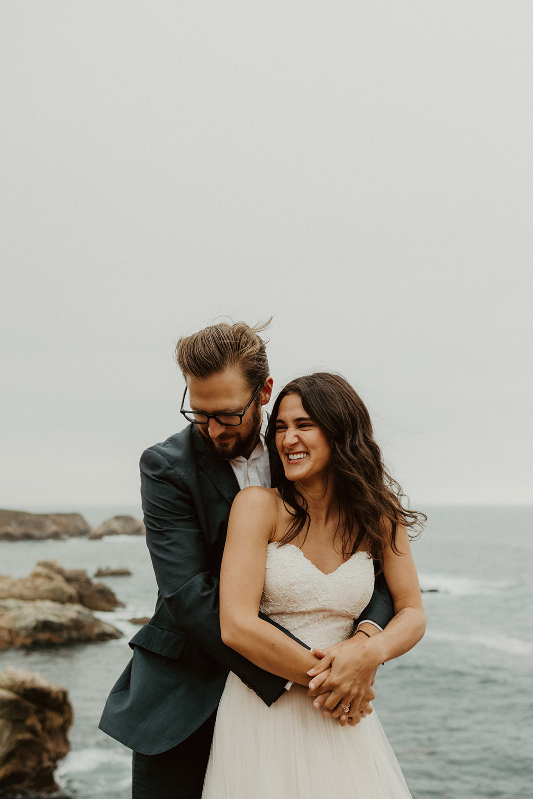 Foggy Elopement in Big Sur with the groom wrapping up the bride in his arms