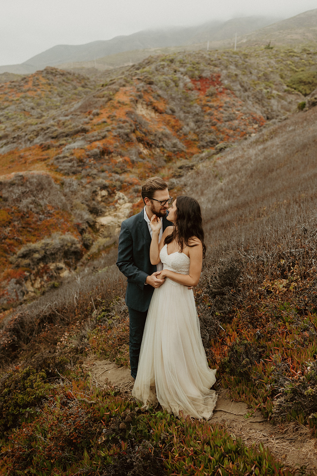 the couple kissing together on the coastline during their foggy elopement in Big Sur