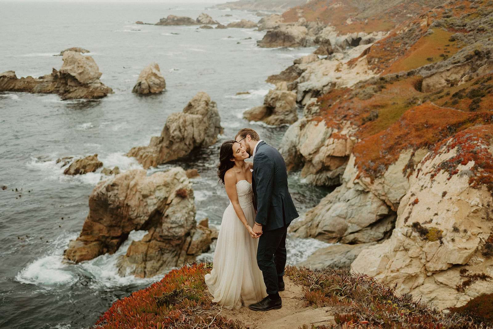 the groom kissing the bride's cheek at their foggy elopement in Big Sur