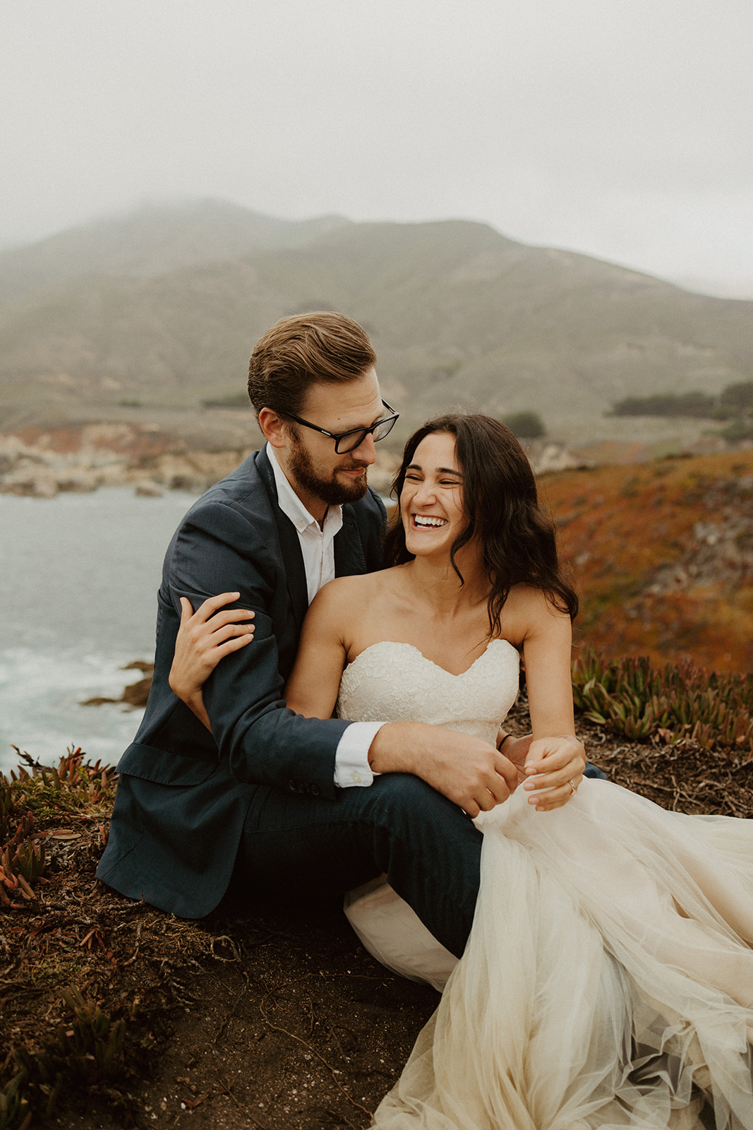 the couple laughing together at their foggy elopement in Big Sur