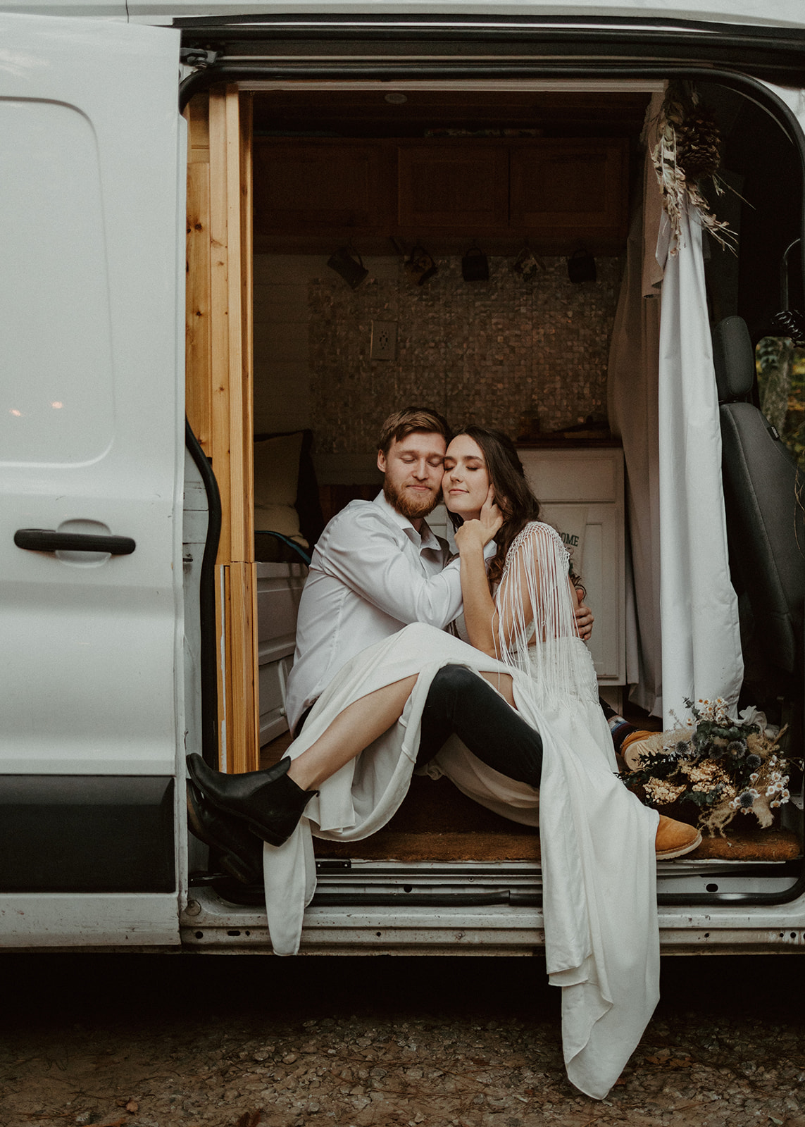 the couple sitting in their conversion van