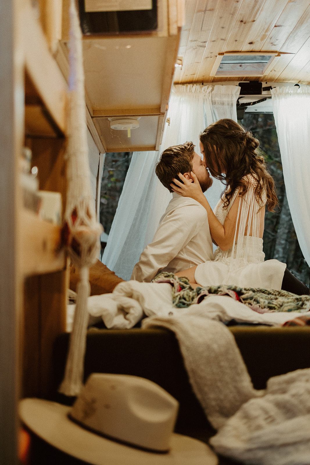 the couple sitting on each other in their conversion van