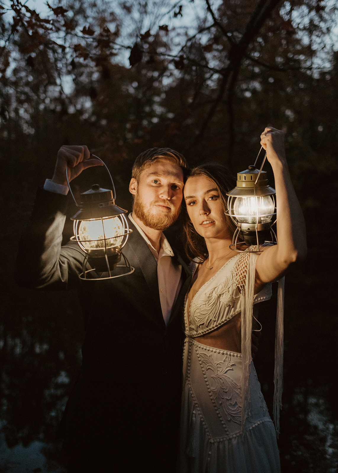 the bride and groom looking at their elopement photographer with lanterns