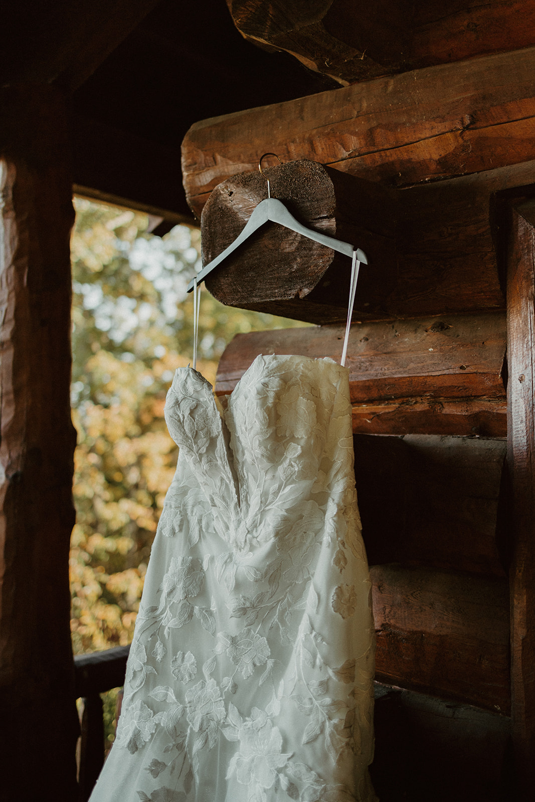 the elopement wedding dress hanging on the side of the elopement cabin