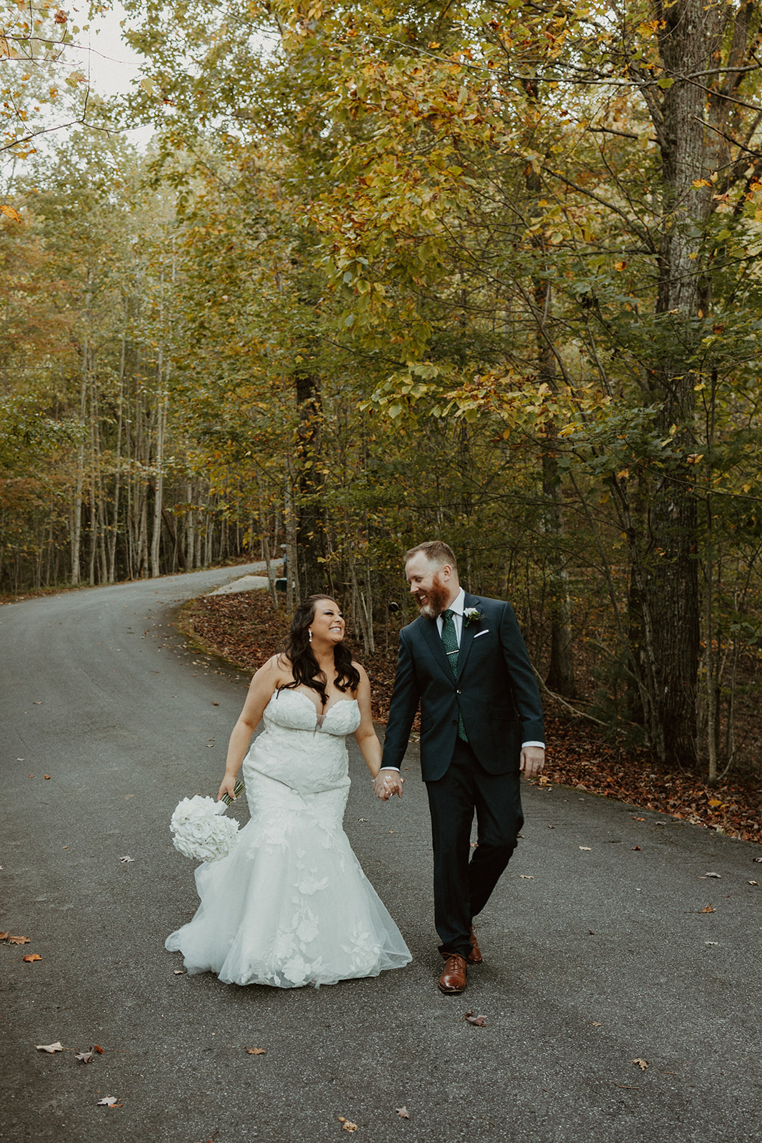 couple walking through the fall leaves at the airbnb wedding venue