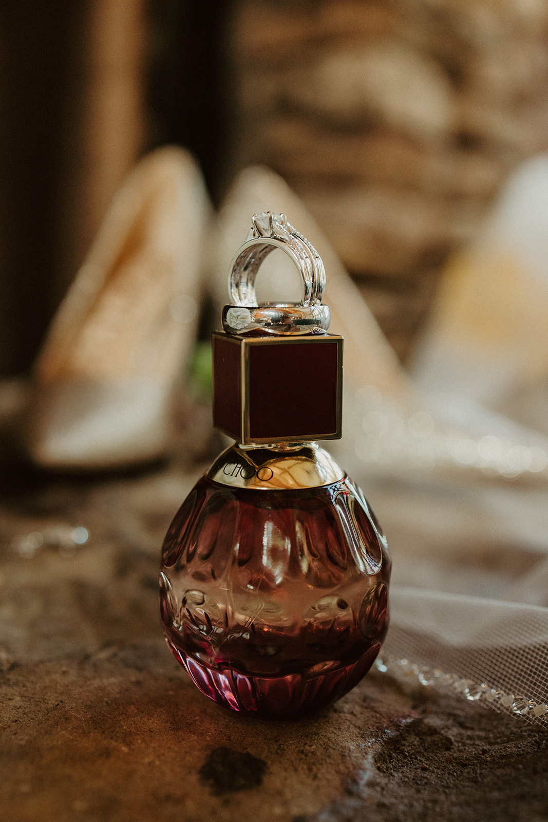 the bottle of perfume and wedding rings