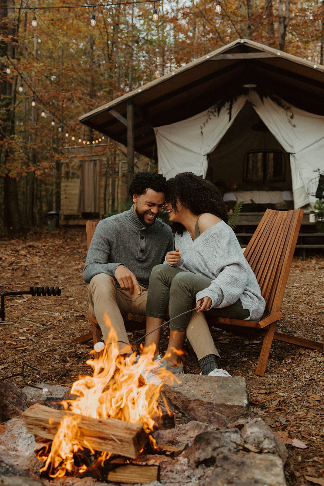 the couple laughing at the campfire together