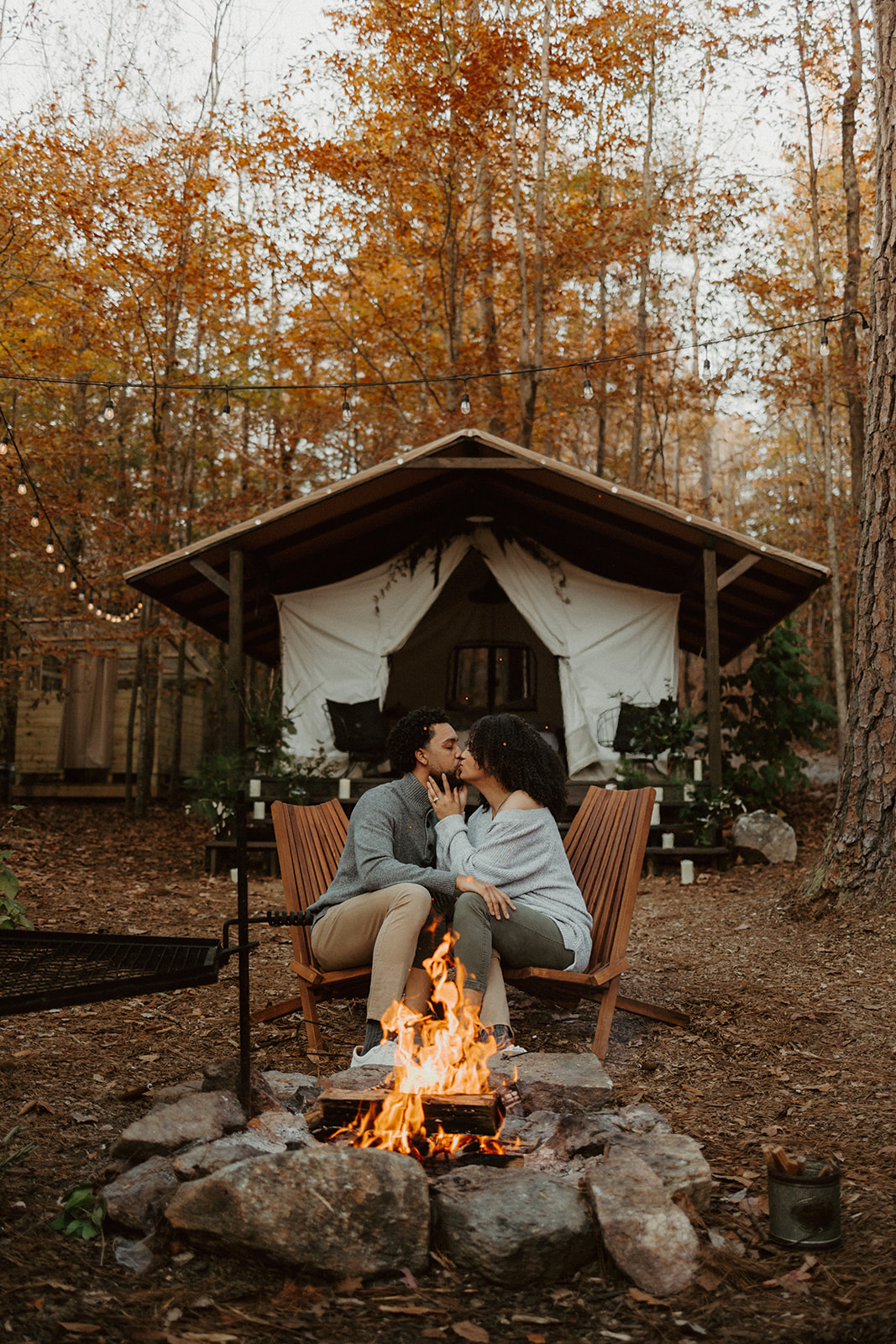 the couple kissing in front of the campfire