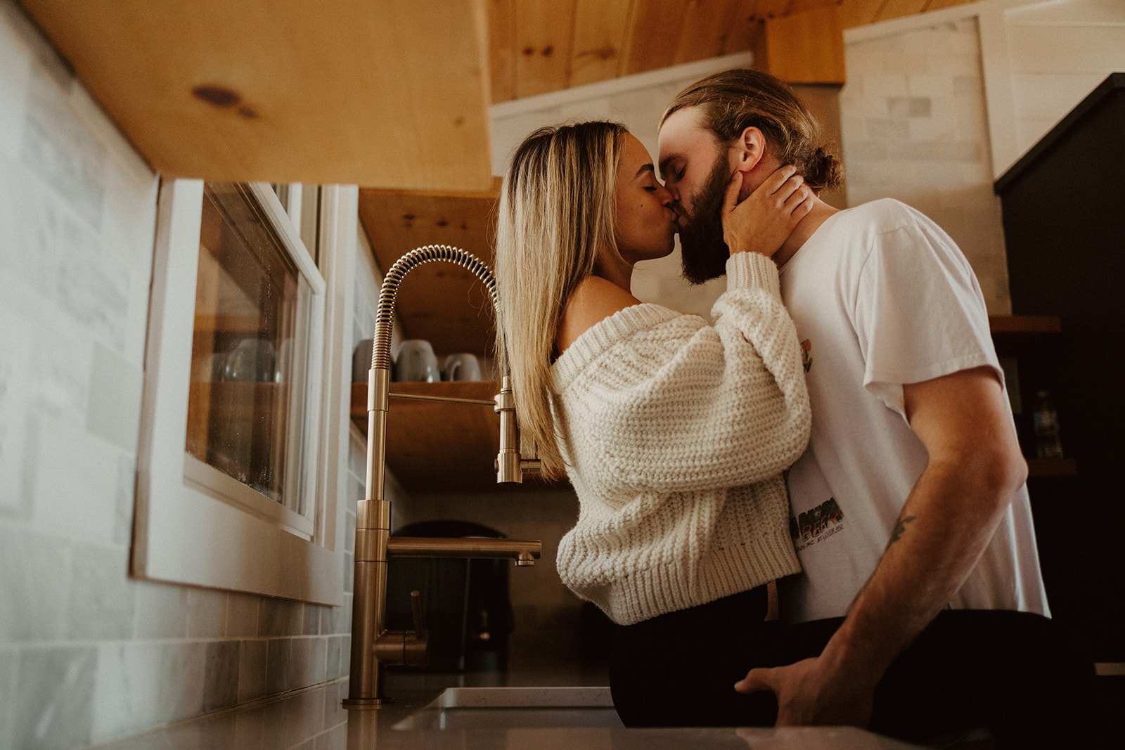the couple kissing in the kitchen