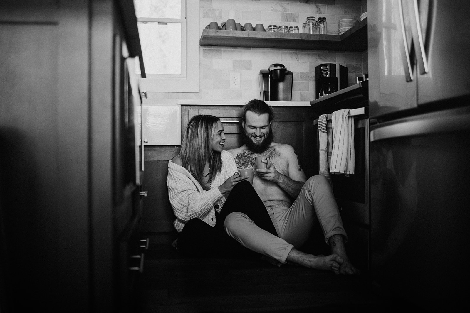 the couple sitting on the kitchen floor together during couple photos