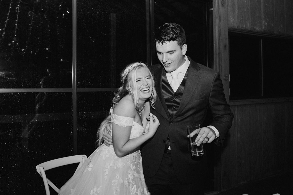 the bride and groom smiling and laughing together at their wedding reception