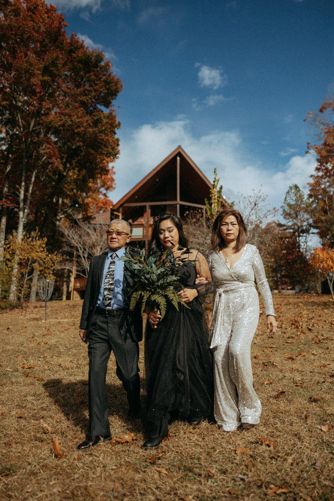 the bride walking down the aisle with her mom and dad at the airbnb