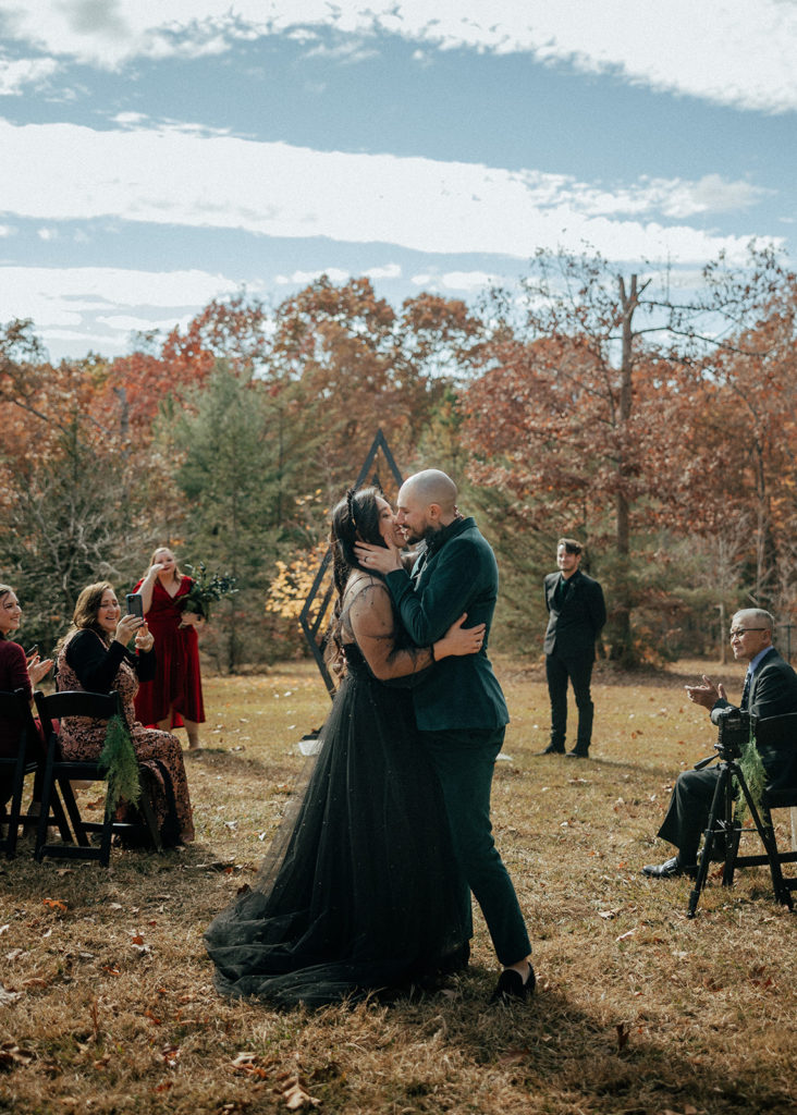 the bride and groom kissing down the wedding aisle