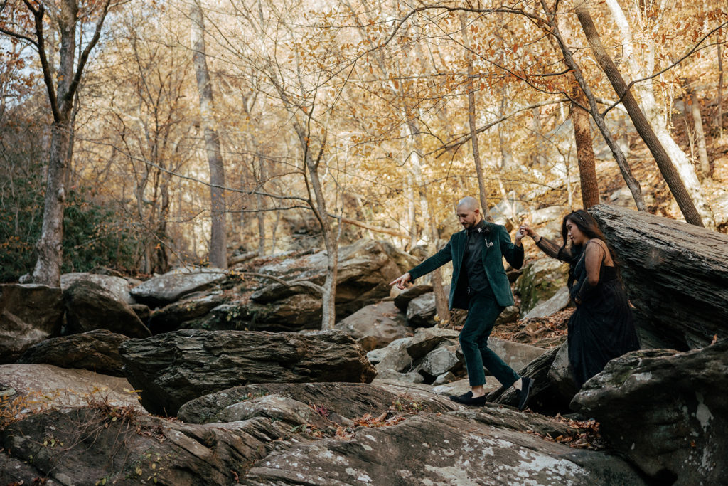 the bride and groom holding hands as they hike together in Mineral Bluff