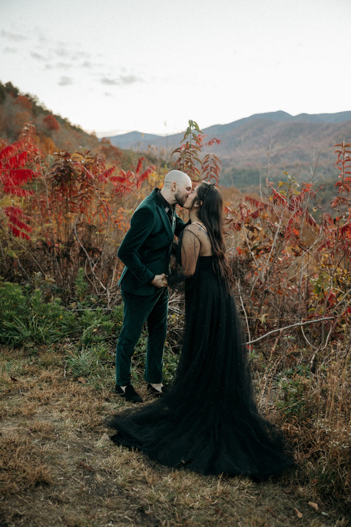 the bride and groom kissing surrounded by the fall trees during their Mineral Bluff elopement