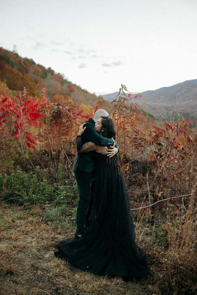 the bride and groom hugging in the mountains during their fall elopement